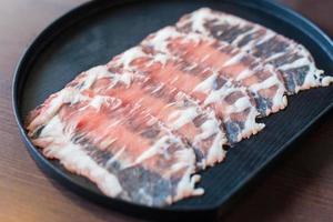 Fresh beef raw sliced was served for Sukiyaki and Shabu or Yakiniku restaurant which it put on black plate. photo