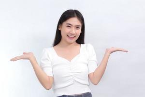 Asian beautiful woman in white shirt shows hand to present something on white background. photo