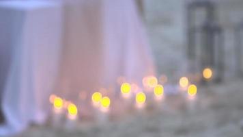 Candlelight bright decoration sandy beach romantic setting table dinner. video