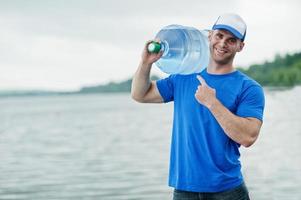 repartidor que lleva una botella de agua en el hombro. foto