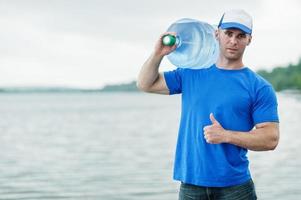 repartidor que lleva una botella de agua en el hombro. foto