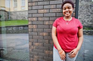 mujer africana usa camiseta roja posando al aire libre. foto