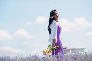 Beautiful indian girl wear saree india traditional dress in purple lavender field. photo