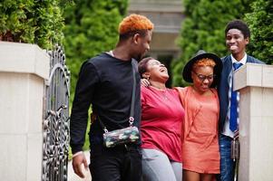 Four african friends having fun outdoors. Two black girls with guys. photo