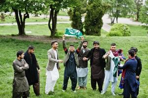 Group of pakistani man wearing traditional clothes salwar kameez or kurta with Pakistan flags. photo