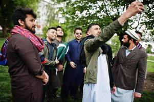 Group of pakistani man wearing traditional clothes salwar kameez or kurta making selfie on mobile phone. photo