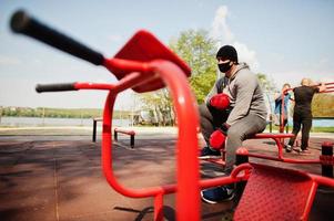 Portrait sports arabian boxer man in black medical face mask boxing outdoor during coronavirus quarantine. photo