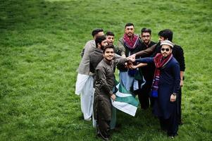 Group of pakistani man wearing traditional clothes salwar kameez or kurta with Pakistan flags. photo