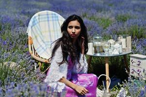 Beautiful indian girl wear saree india traditional dress sitting in purple lavender field with decor. photo