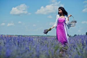 hermosa niña india usa vestido tradicional saree india en campo de lavanda púrpura. foto