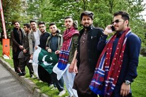 Group of pakistani man wearing traditional clothes salwar kameez or kurta with Pakistan flags. photo