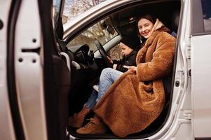 Young mother and child in car. Safety driving concept. photo