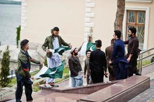 Group of pakistani man wearing traditional clothes salwar kameez or kurta with Pakistan flags. photo