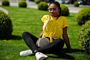 retrato de mujer afroamericana negra con camiseta amarilla y gafas. foto