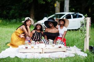 Group of african american girls celebrating birthday party and clinking glasses outdoor with decor. photo