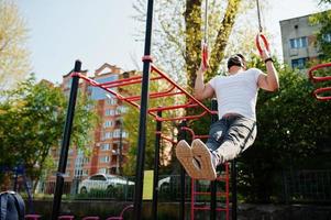 Portrait sports arabian man in black medical face mask doing workout exercises in outdoor gym place during coronavirus quarantine. photo