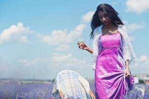 hermosa niña india usa vestido tradicional saree india en campo de lavanda púrpura. foto