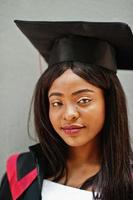 Young female african american student with diploma poses outdoors. photo