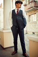 Portrait of retro 1920s english arabian business man wearing dark suit, tie and flat cap. photo