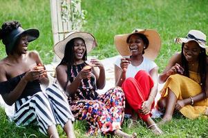Group of african american girls celebrating birthday party and eat muffins outdoor with decor. photo