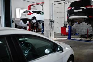 Cars lifting in maintenance at garage service station. photo