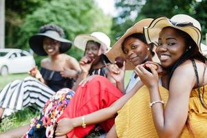 Group of african american girls celebrating birthday party and eat muffins outdoor with decor. photo