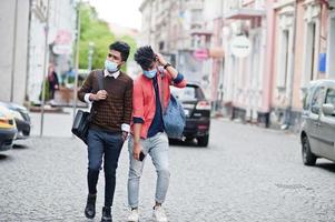 Coronavirus covid-19 concept. Two south asian indian man wearing mask for protect from corona virus walking at city. New normal lifestyle post pandemic in India. photo