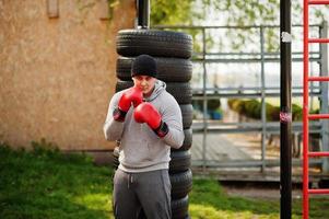 Man arabian boxer in hat training for a hard fight outdoor gym. photo