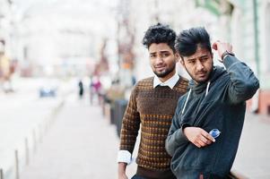 Two young stylish indian man frieds model posing in street. photo