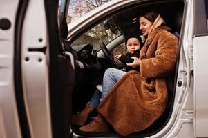 joven madre e hijo en coche. concepto de conducción segura. foto