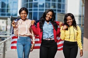 tres jóvenes universitarias amigas afroamericanas con bandera de estados unidos. foto