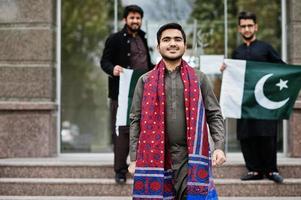 grupo de hombres paquistaníes vestidos con ropa tradicional salwar kameez o kurta con banderas de pakistán. foto