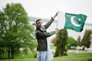 Traditional clothes indian pakistani male portrait hold Pakistan flag. photo