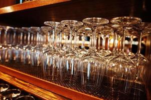 Glasses of wine upside down at bar counter. photo