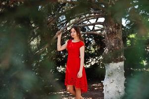 Teenage girl in red dress posed outdoor at sunny day. photo