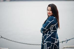 Brunette indian woman in long fashionable dress posed outdoor. photo