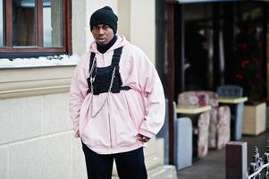 Elegante hombre afroamericano de estilo urbano con capucha rosa posó. foto