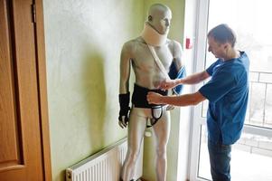Doctor worker works with mannequin cast on arm and neck at prosthetist clinic. photo