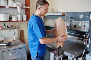 Prosthetist man making prosthetic leg while working in laboratory. photo