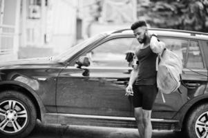 African american male athlete sport man with backpack against his black suv car before training. photo