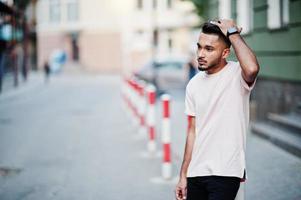 Stylish indian beard man at pink t-shirt. India model posed outdoor at streets of city. photo