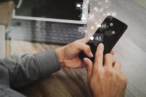 Hand using mobile payments online shopping,omni channel,icon customer network,in modern office wooden desk, blank interface screen,filter effect photo