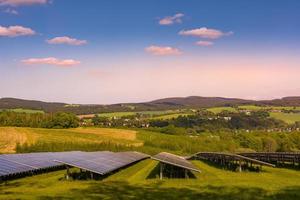 Solar farm with photovoltaic panels at sunset photo