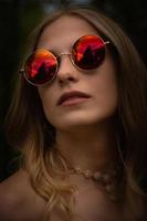 mujer con gafas de sol redondas rojas foto
