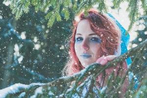 atractiva mujer pelirroja en capa de invierno foto