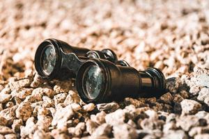 old binoculars on pebbles photo