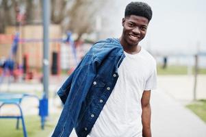 joven africano milenario en la ciudad. hombre negro feliz con chaqueta de jeans. concepto de generación z. foto