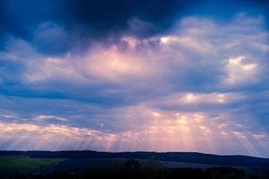 sunset with clouds and sunbeams photo