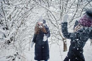 Two funny girls friends having fun at winter snowy day near snow covered trees. photo