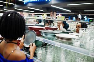 Group of african womans look color plates on supermarket shelves. photo